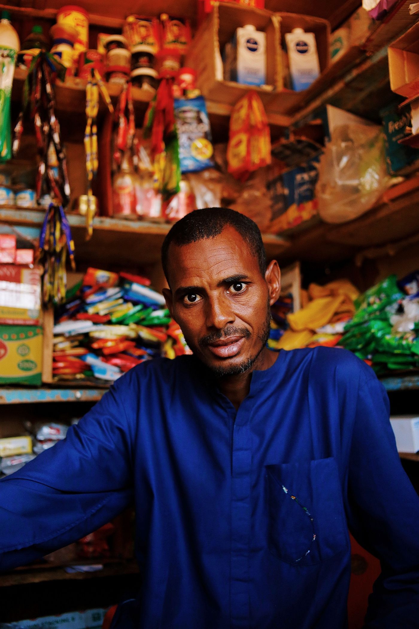 A shopkeeper in his neighbourhood store in Abuja, Nigeria