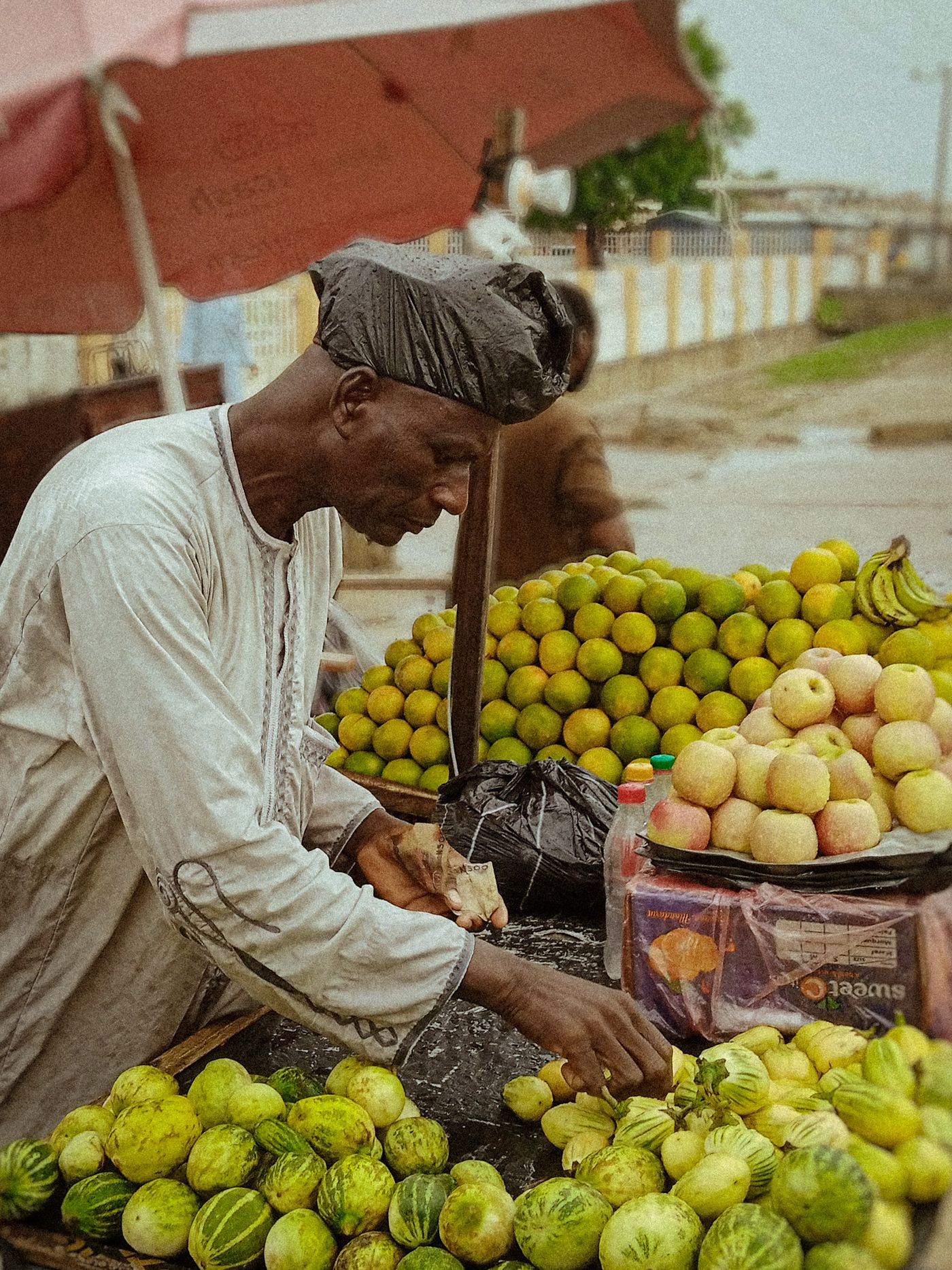 A fruit seller selecting fresh produce in Nigeria